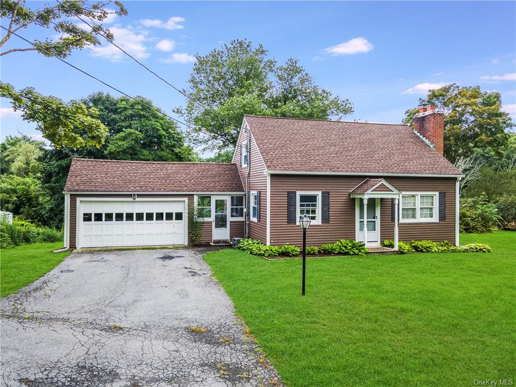 View of front of house with a front yard and a garage