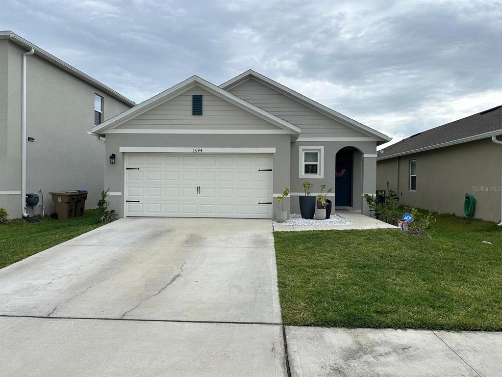 a front view of a house with a yard and garage