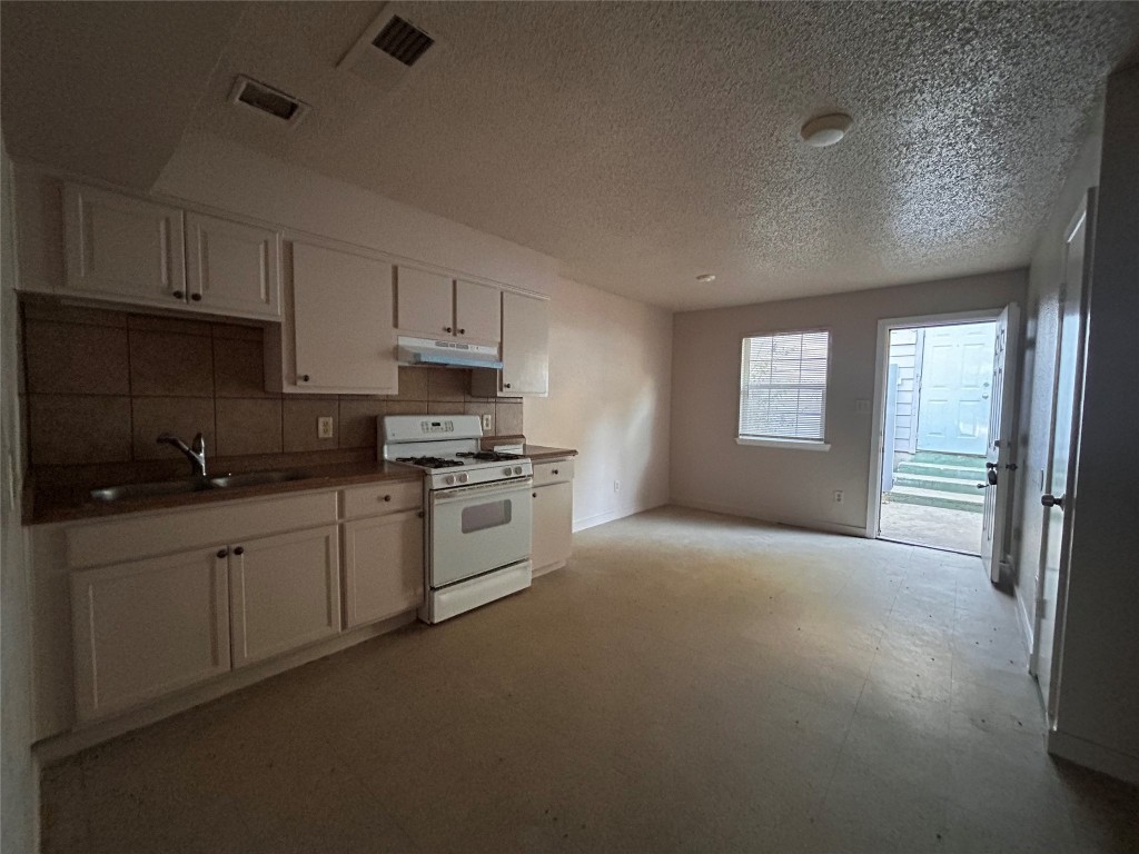 a kitchen with granite countertop white cabinets and white appliances