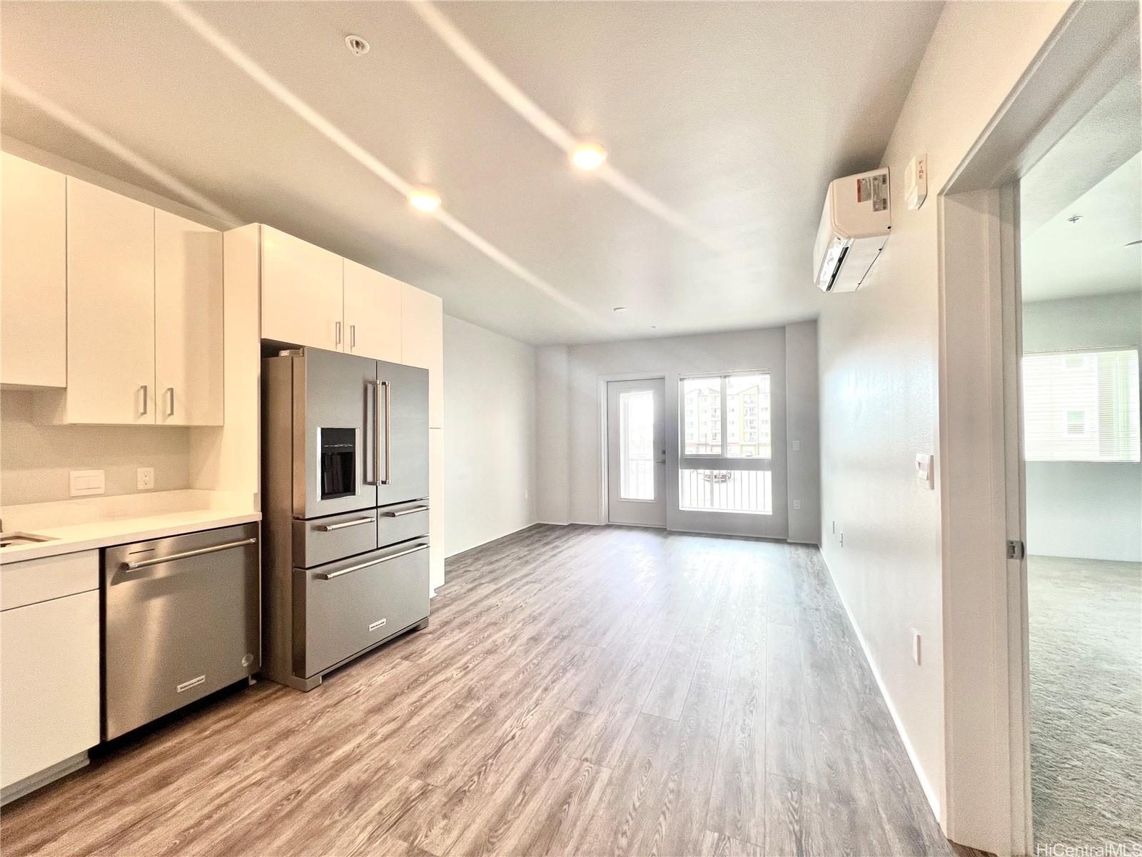 a view of a kitchen from the hallway with a sink and wooden floor