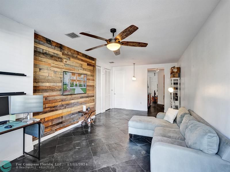 a living room with furniture and a ceiling fan