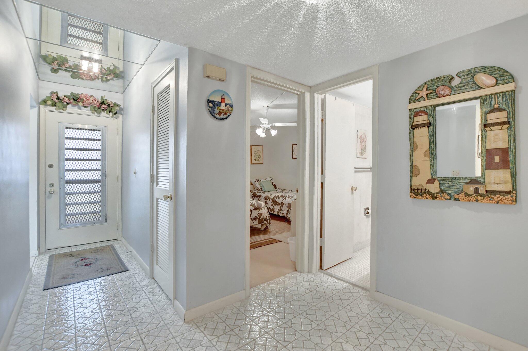 a view of a hallway with closet and bathroom