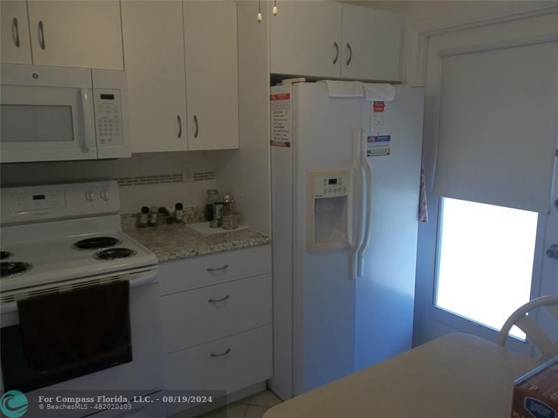 a kitchen with stainless steel appliances granite countertop a refrigerator and a stove