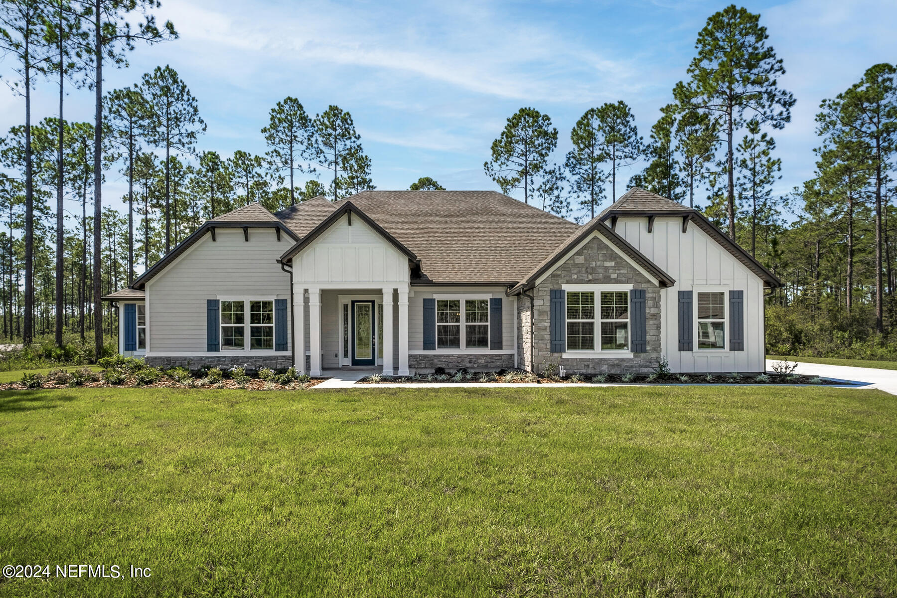 a white house with a yard and wooden fence