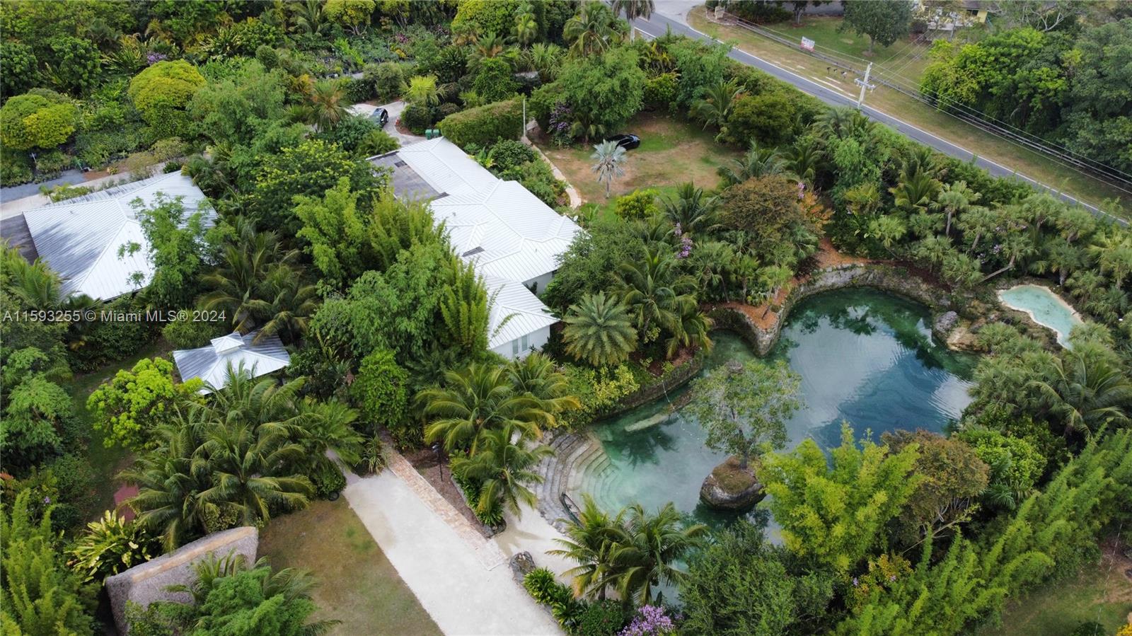 an aerial view of residential house with outdoor space and trees all around