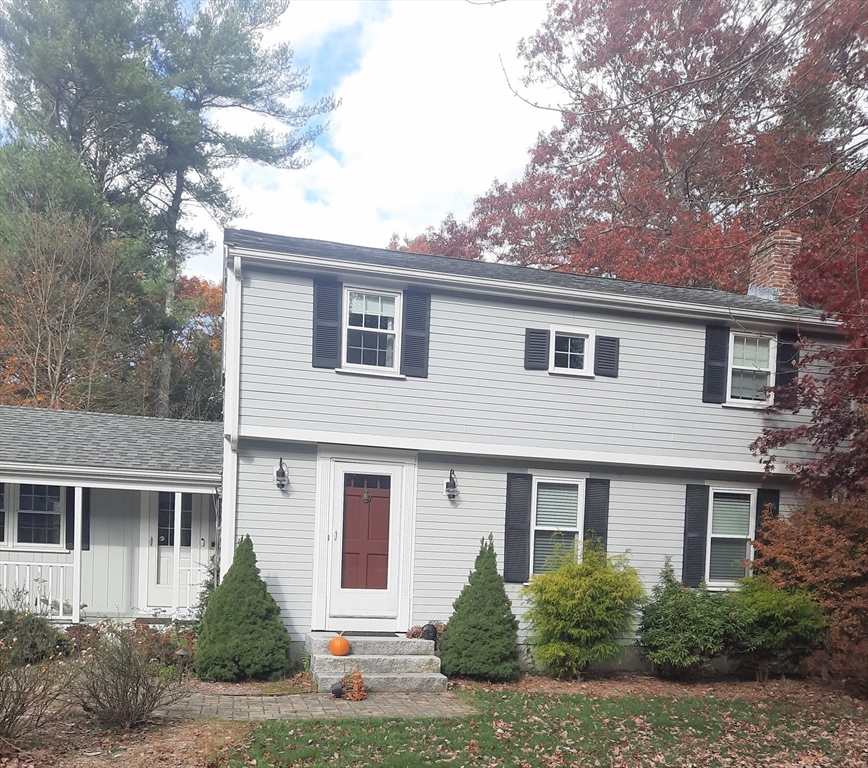 a front view of a house with plants and trees