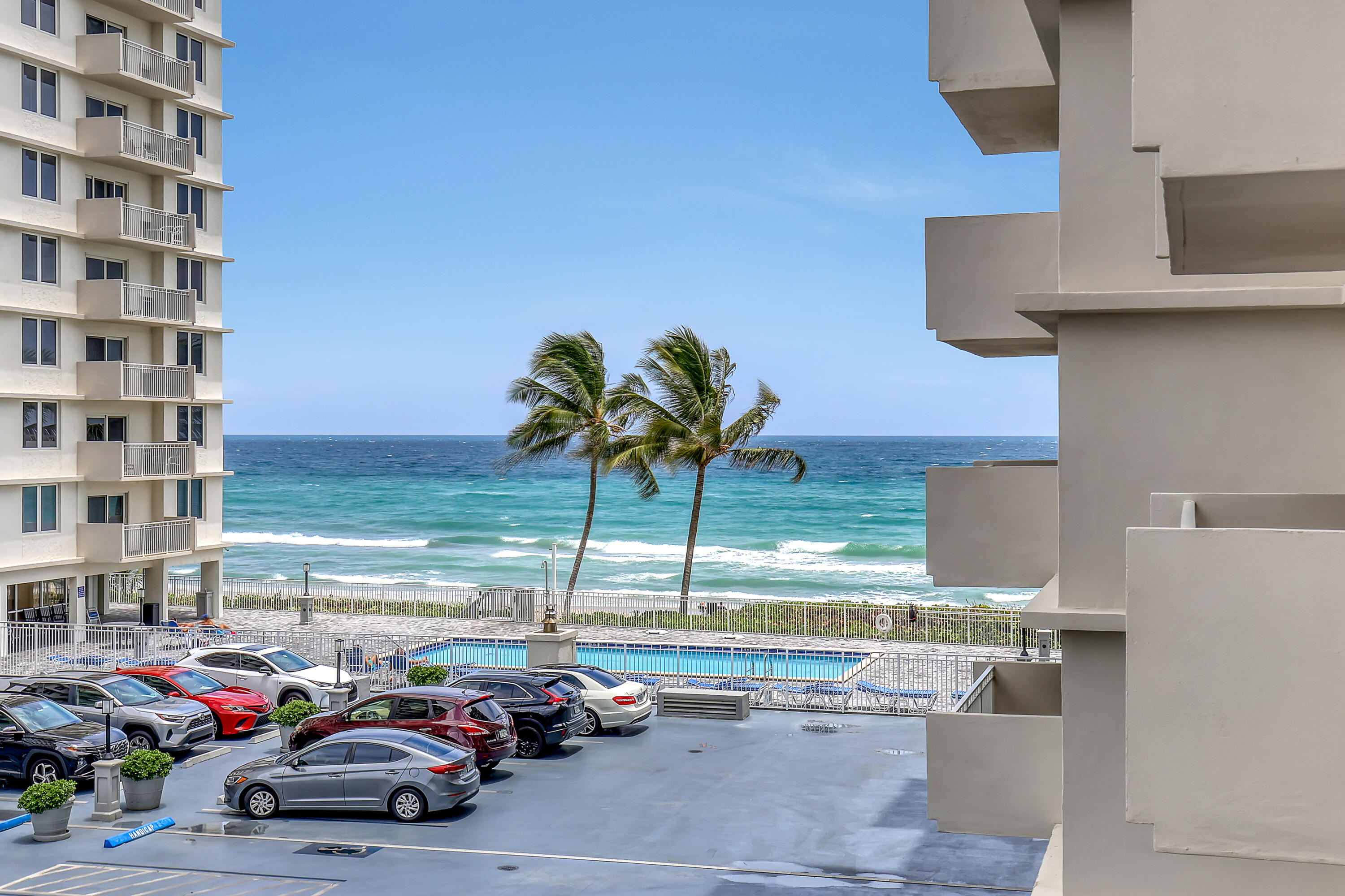 a view of building with cars parked across