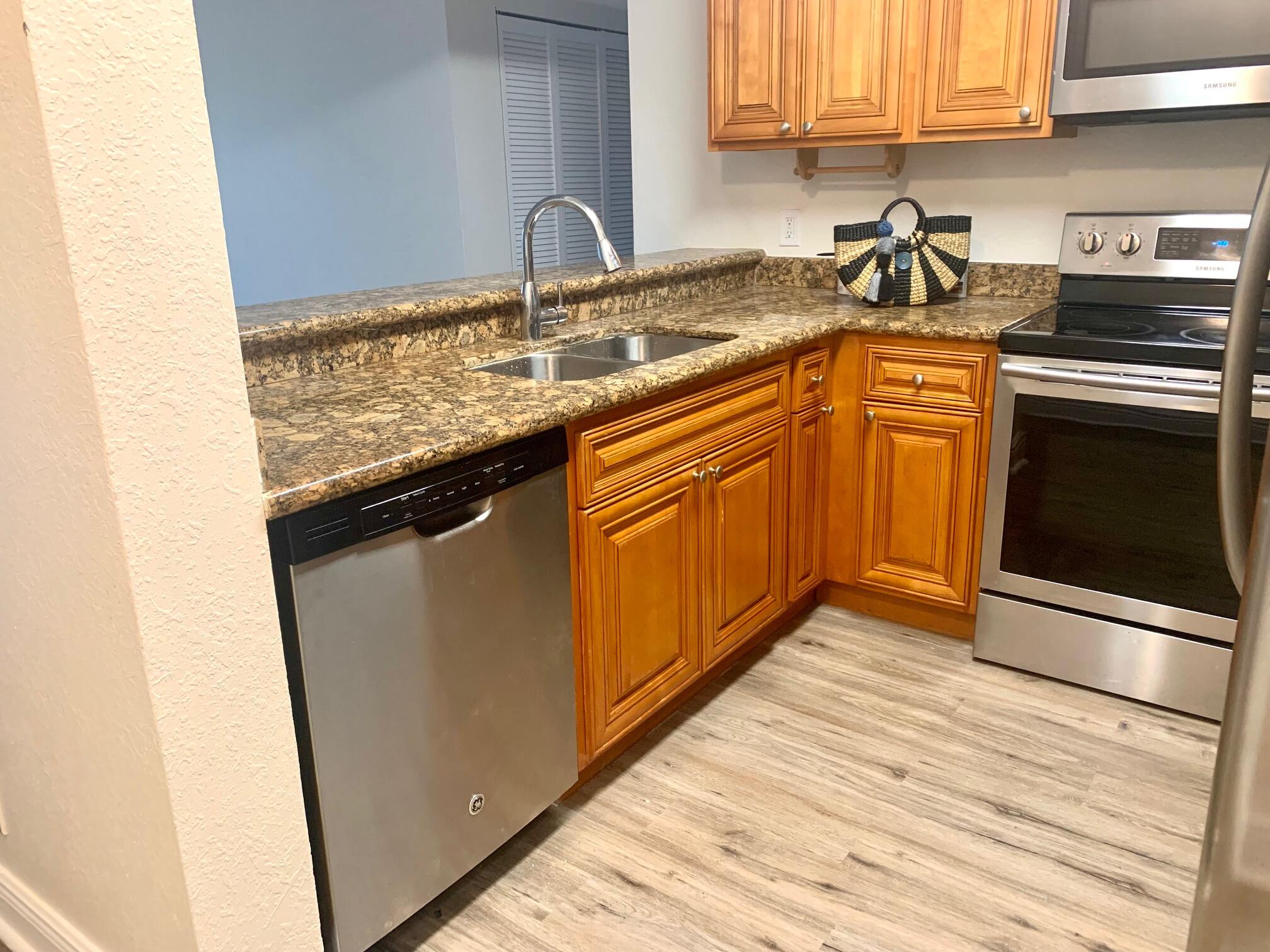 a kitchen with stainless steel appliances granite countertop a sink stove and cabinets