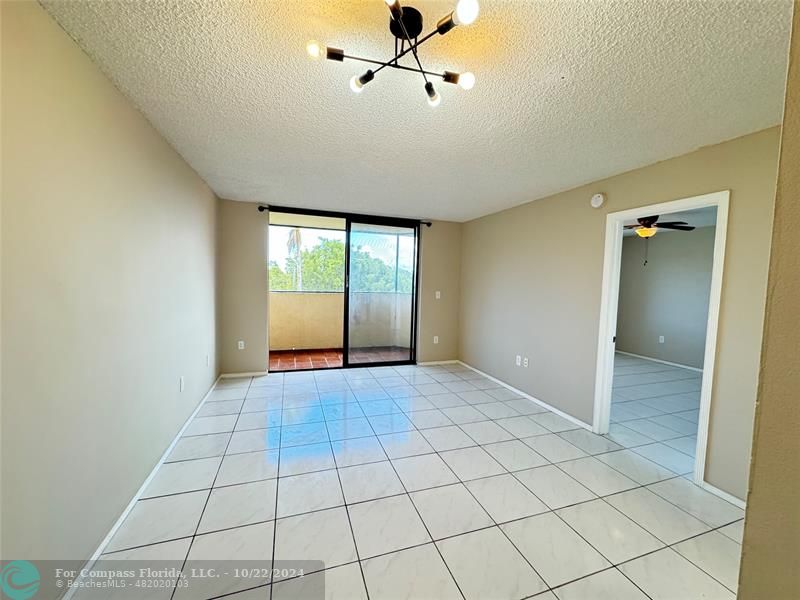 a view of an empty room and window chandelier fan