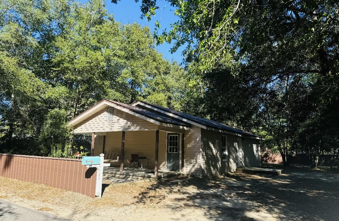 a front view of a house with a tree