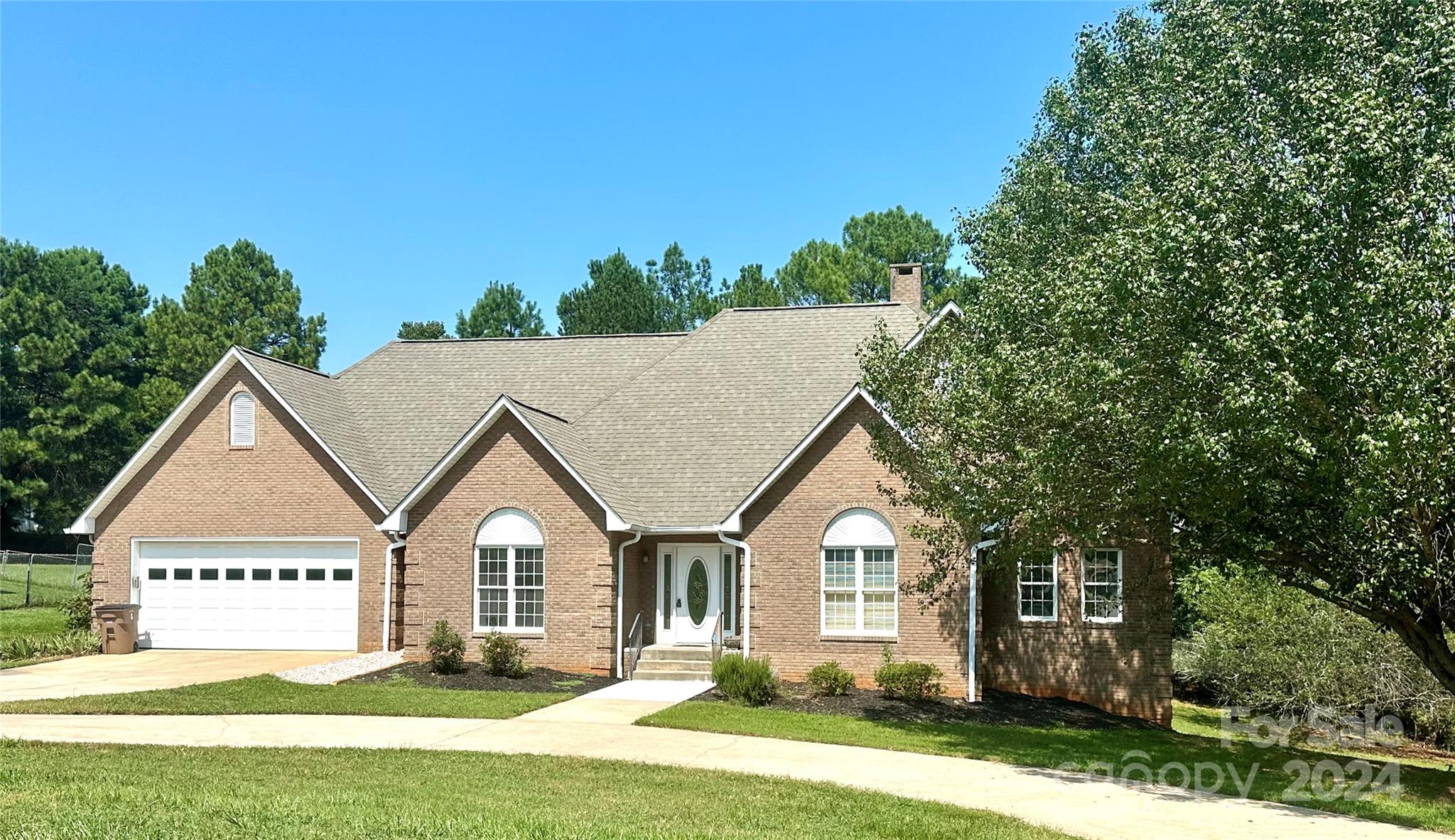 a front view of a house with a garden and yard