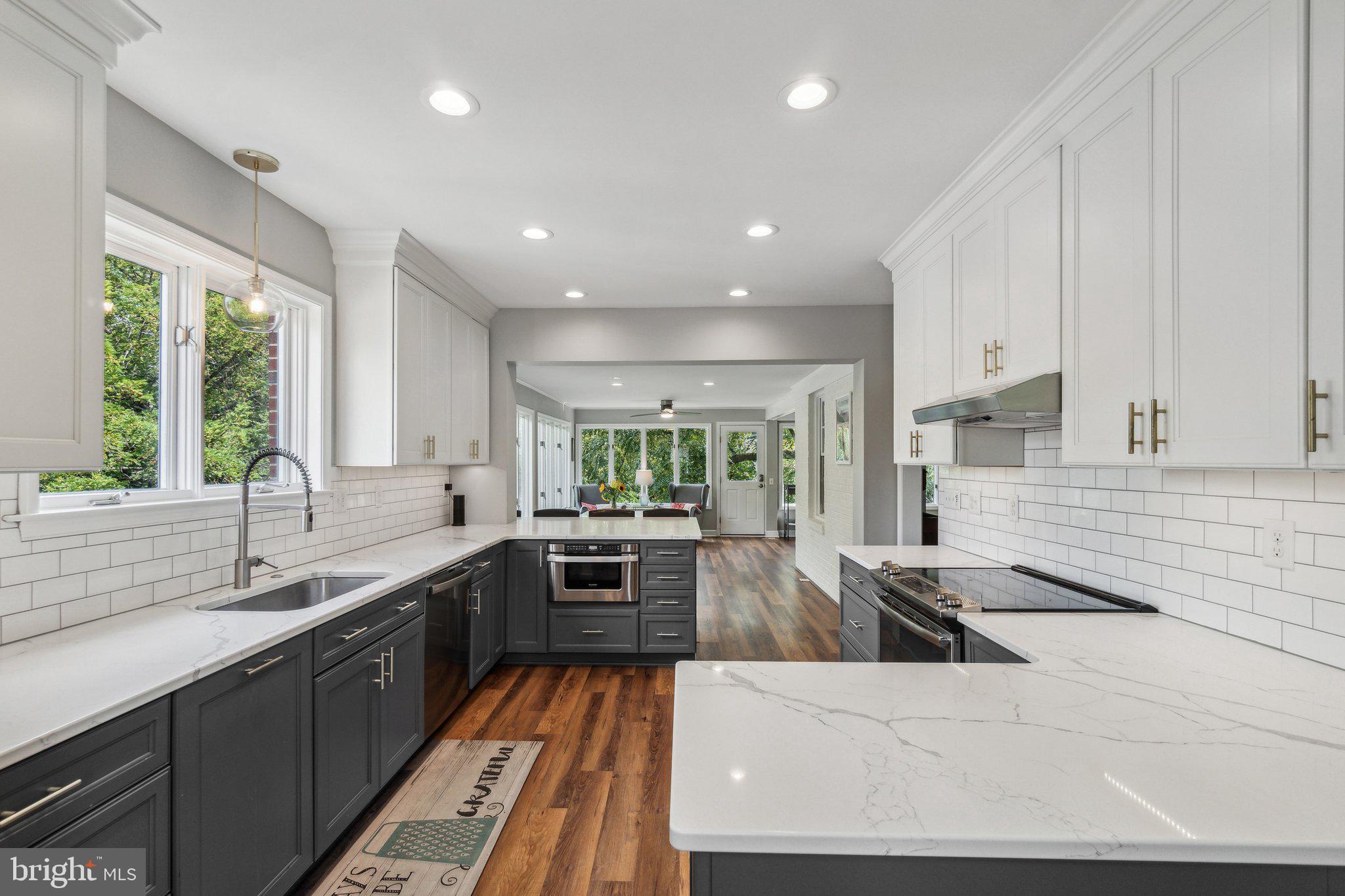 a large kitchen with kitchen island a sink stainless steel appliances and cabinets