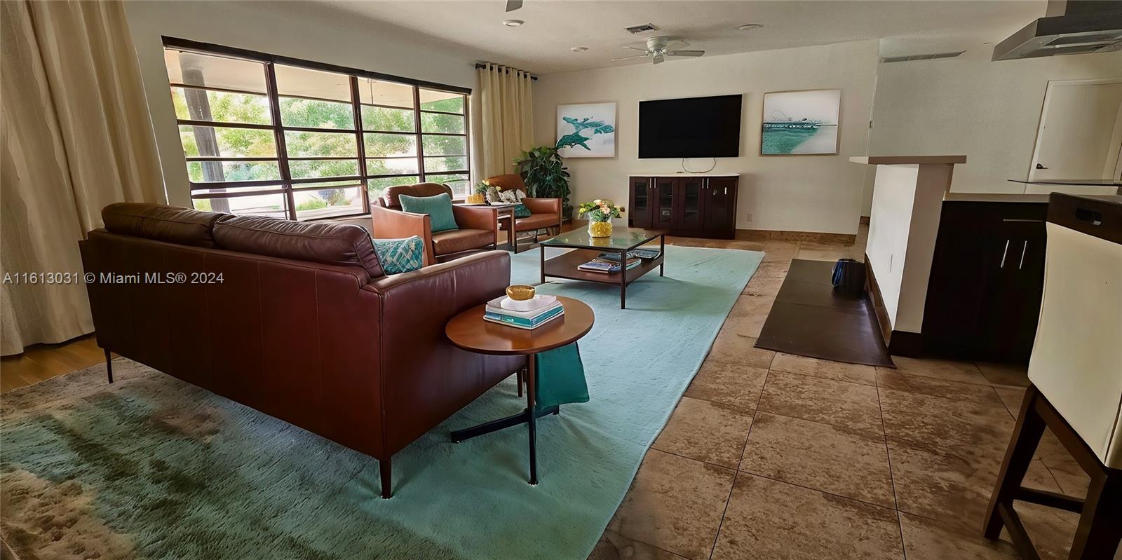 a living room with furniture a flat screen tv and a fireplace