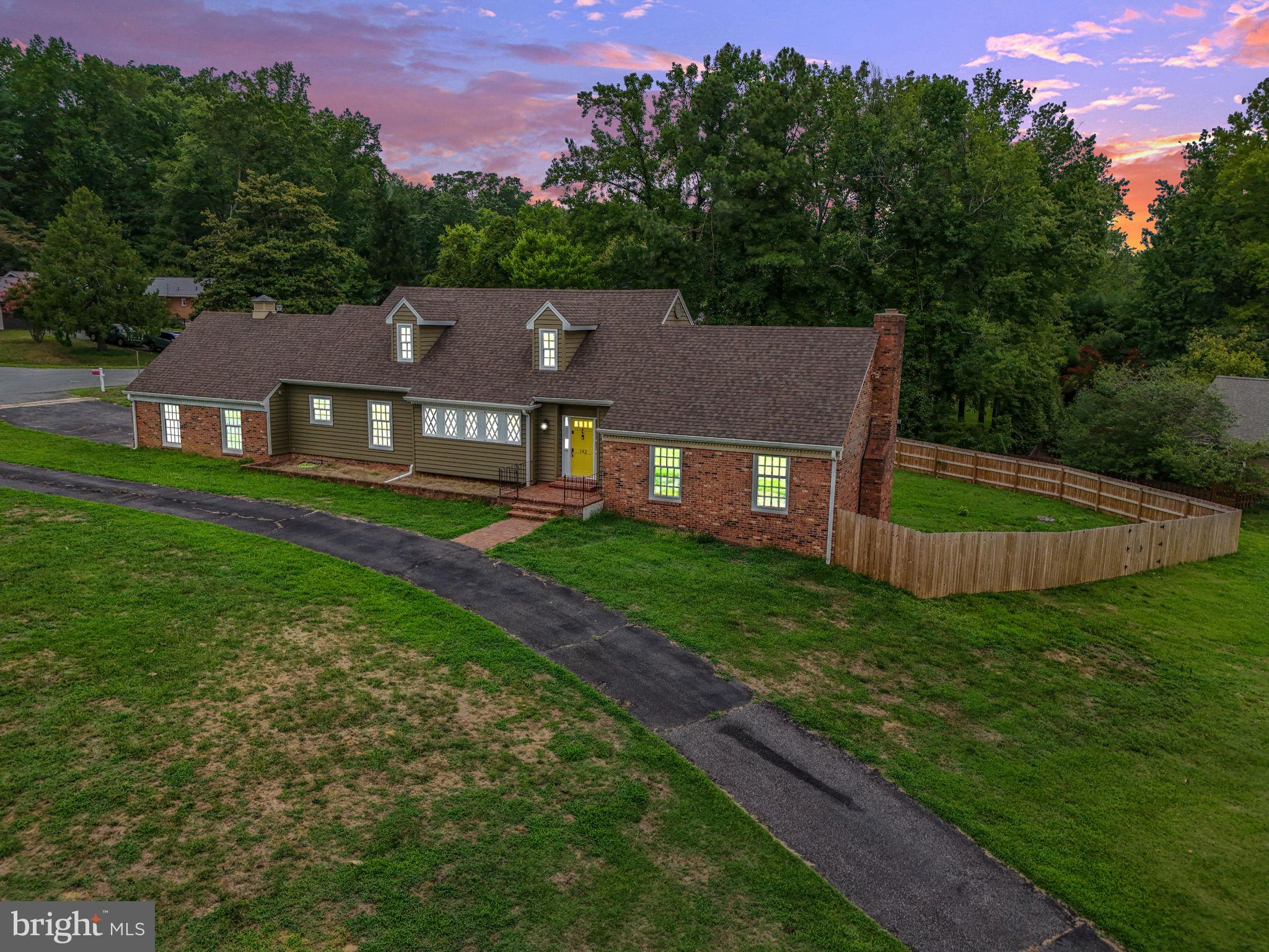 a aerial view of a house next to a big yard and large trees