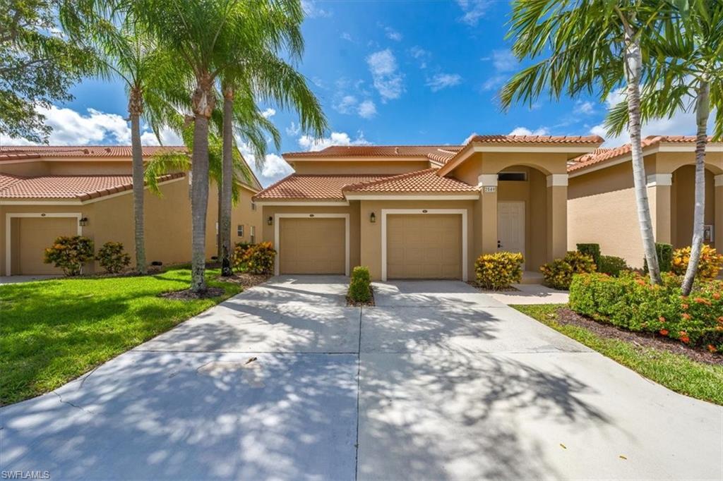 a view of a white house with a yard and palm trees