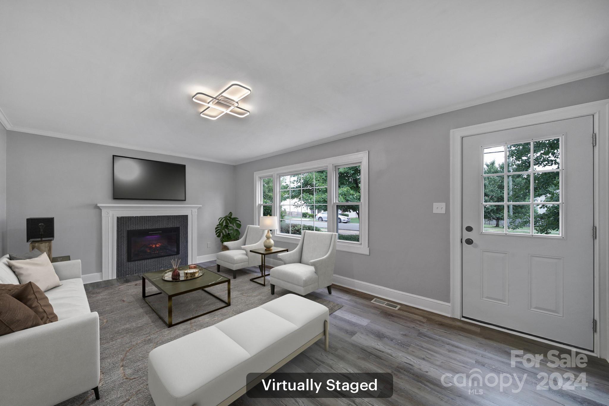 a living room with furniture a chandelier and a fireplace