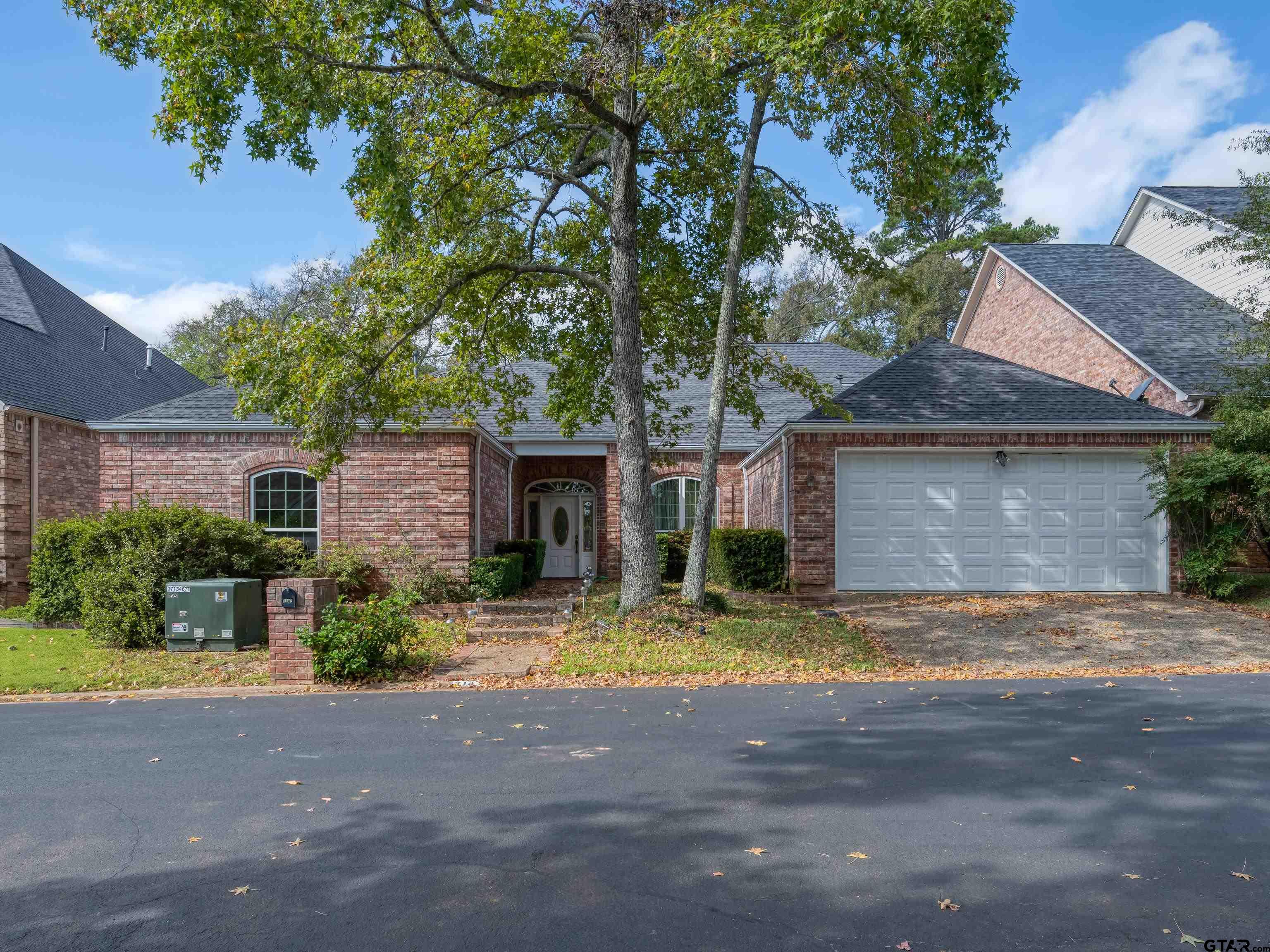 a view of the house with yard and tree s