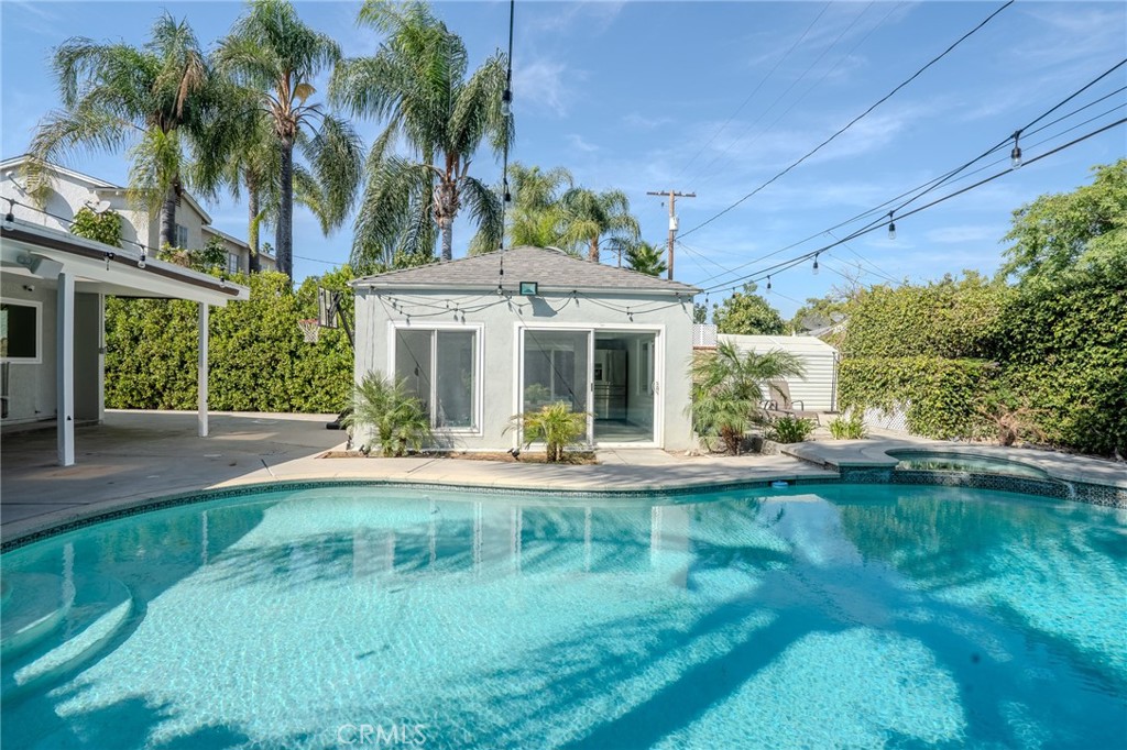 a view of a house with pool and a yard