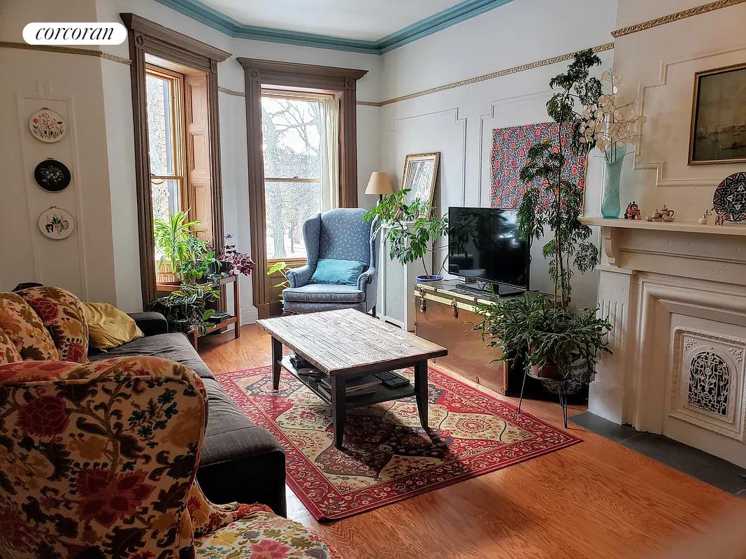 a living room with furniture a fireplace and a potted plant