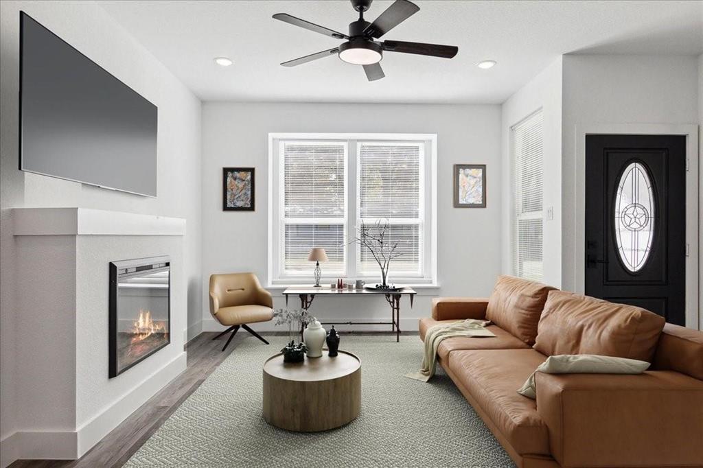 a living room with furniture a fireplace and a large window