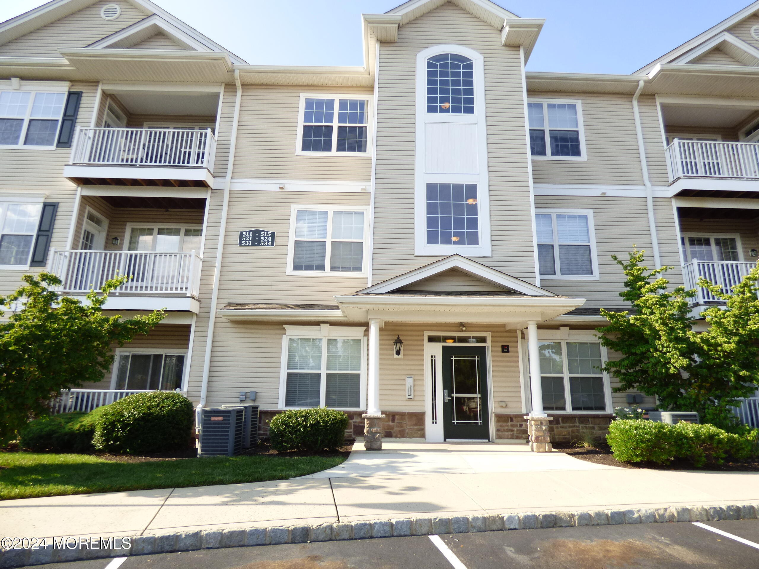 a front view of a residential apartment building with a yard