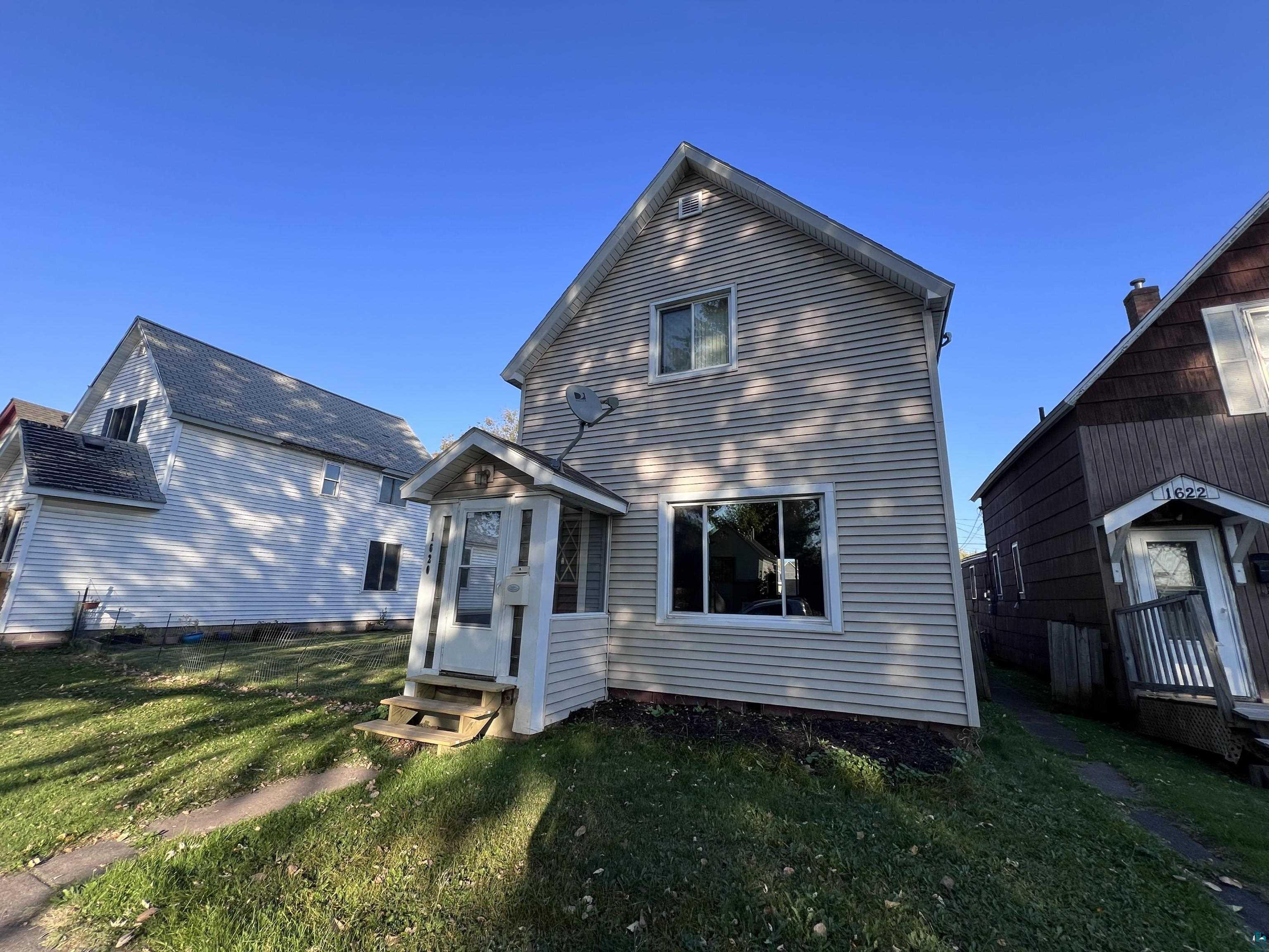 Rear view of property with a yard