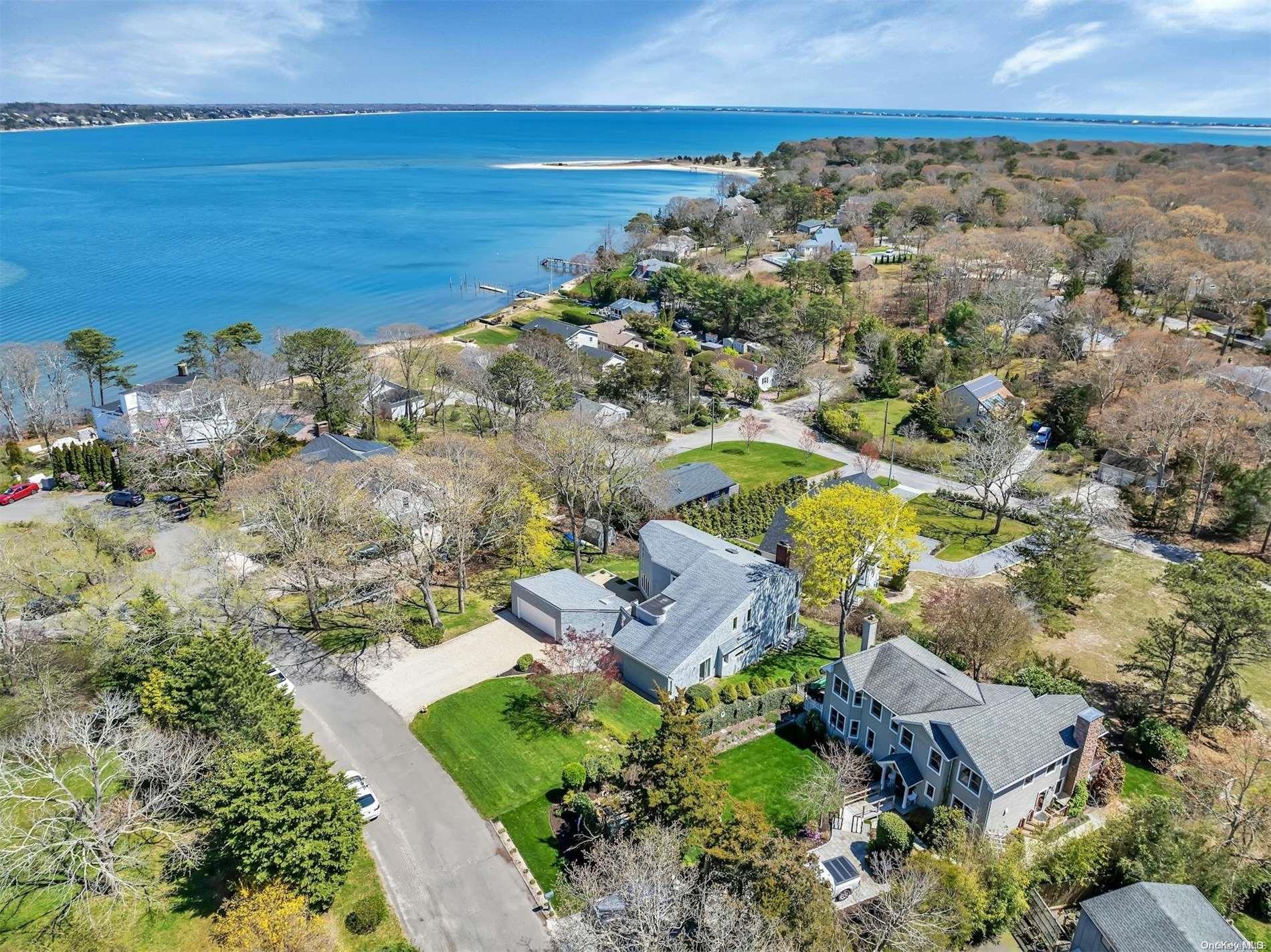 an aerial view of ocean and residential houses with outdoor space