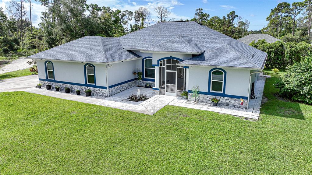 a aerial view of a house with table and chairs in the yard