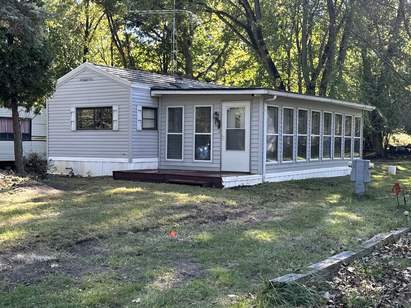 a view of a house with a yard deck and a small yard