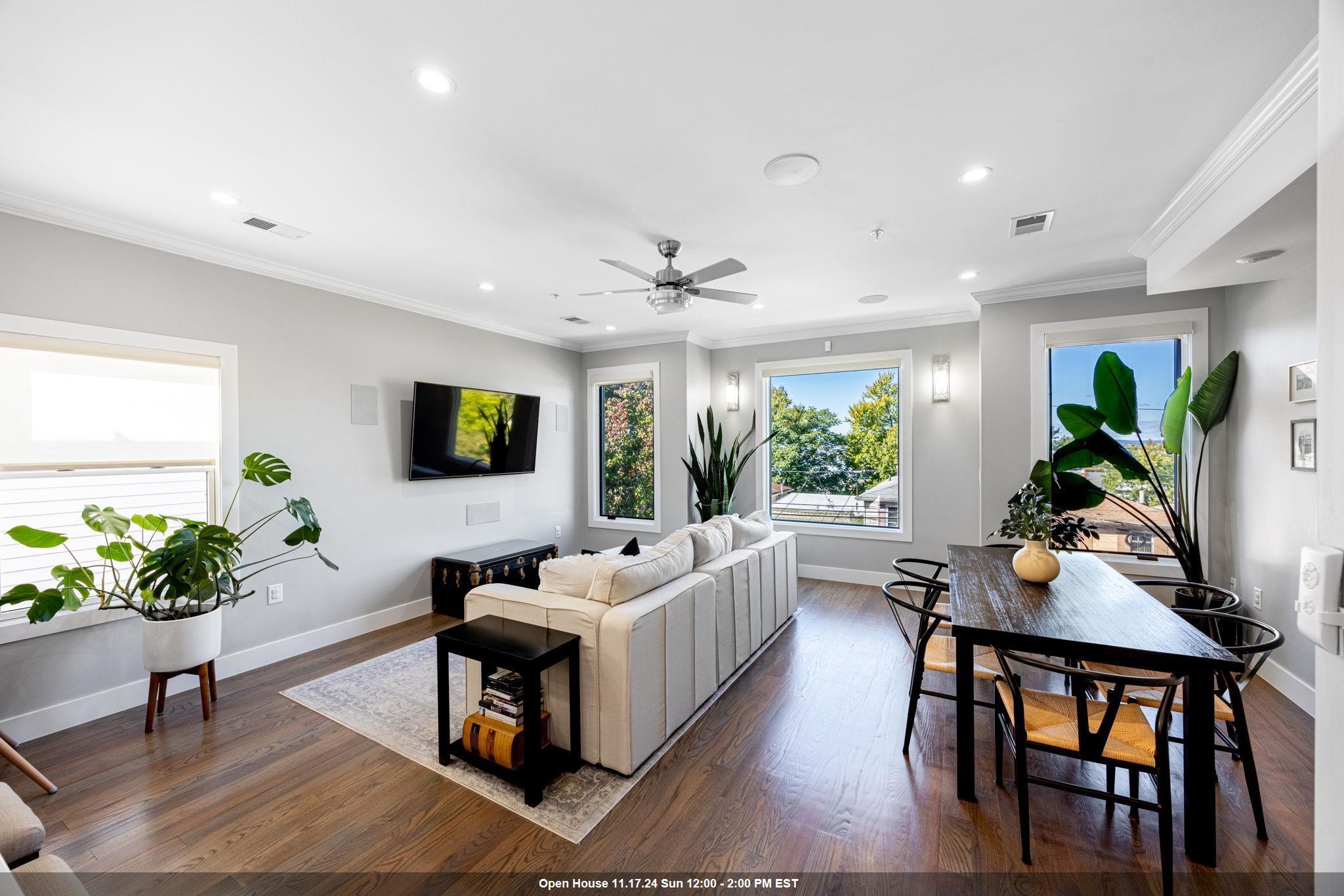 a living room with furniture a window and a potted plant