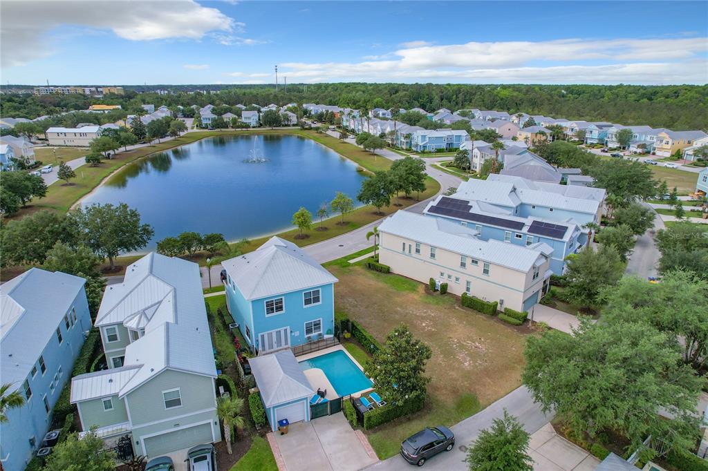 an aerial view of residential houses with outdoor space and lake view