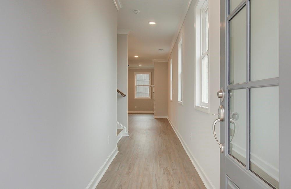 a view of a hallway with wooden floor and staircase