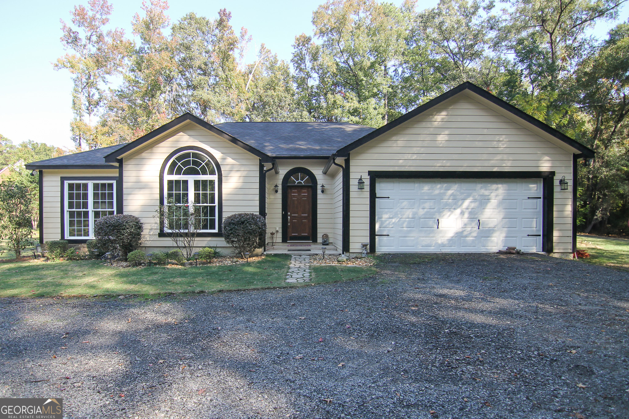 a view of a house with a yard and large tree