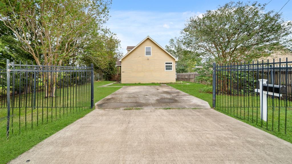 a view of a backyard with brick wall and a large tree