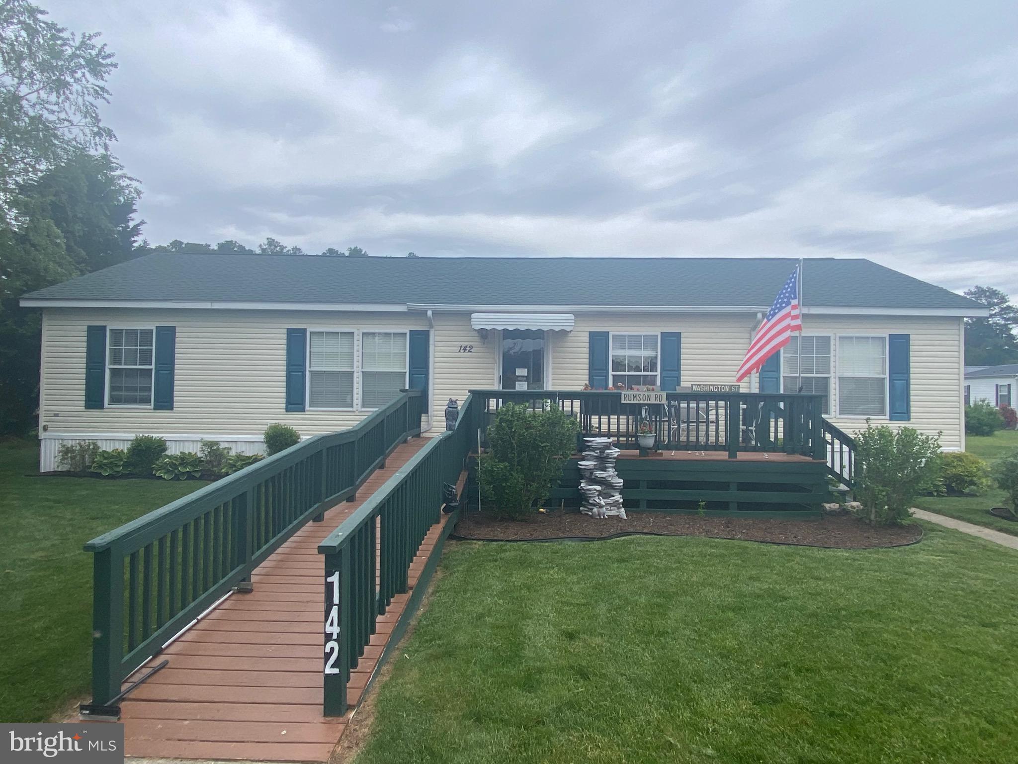 a view of house with a yard and potted plants