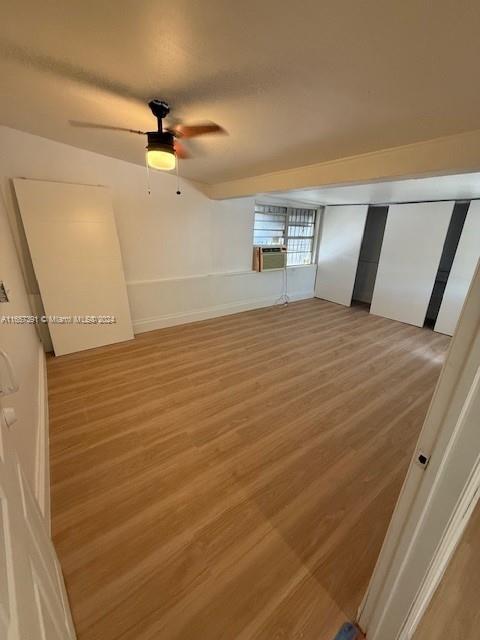 a view of empty room with windows and ceiling fan