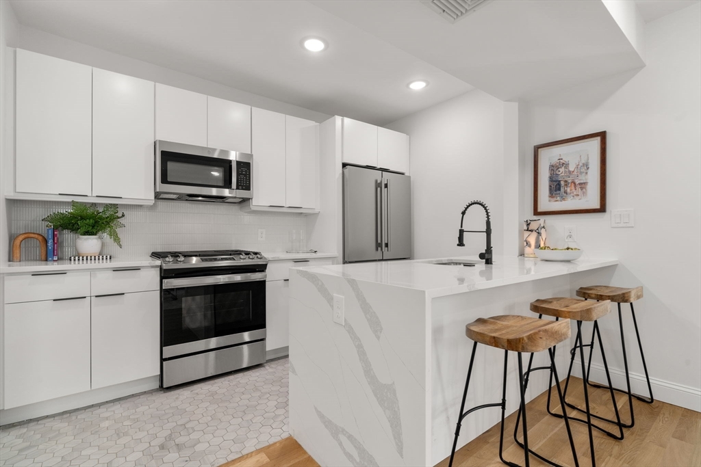 a kitchen with stainless steel appliances a stove a sink a microwave and cabinets