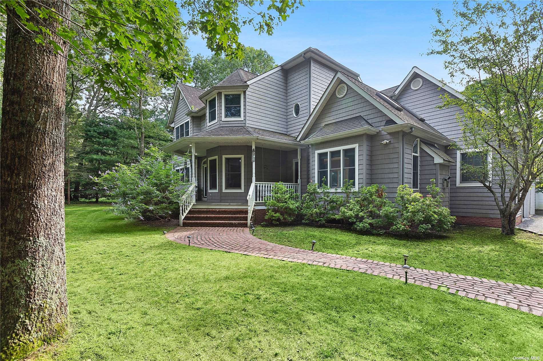 a front view of a house with a yard and green space