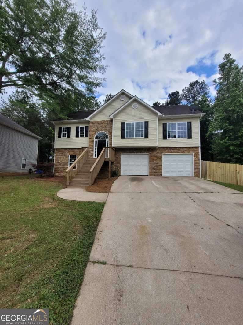 a front view of a house with a yard and trees