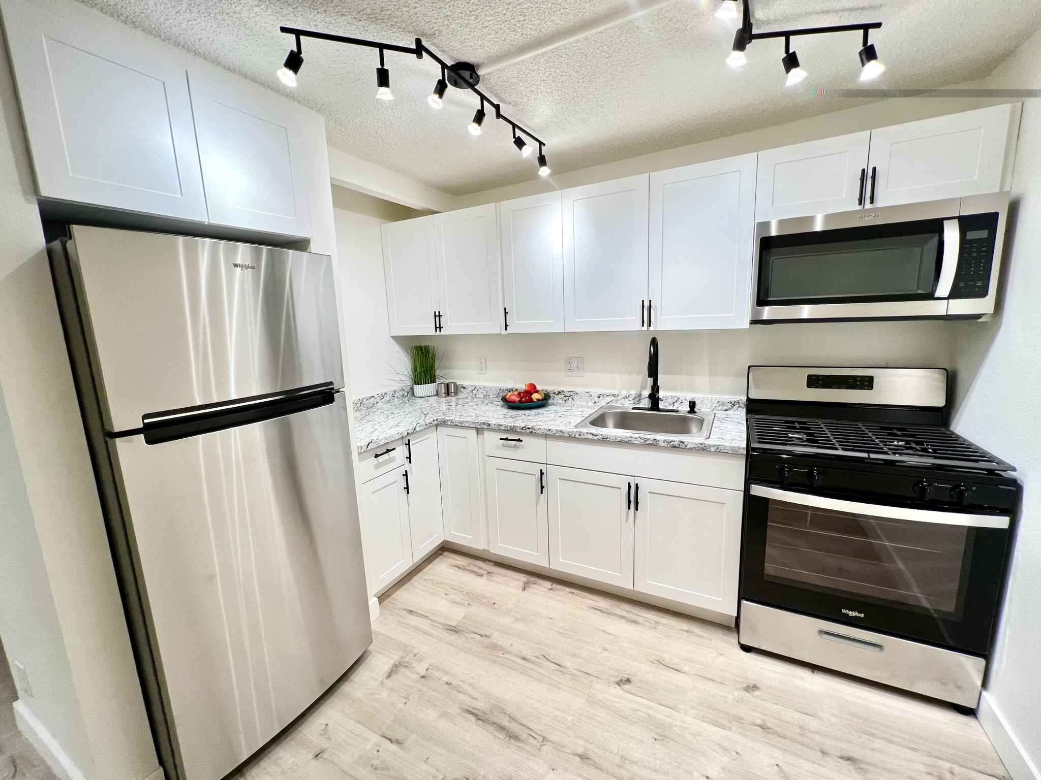 a kitchen with white cabinets stainless steel appliances and sink