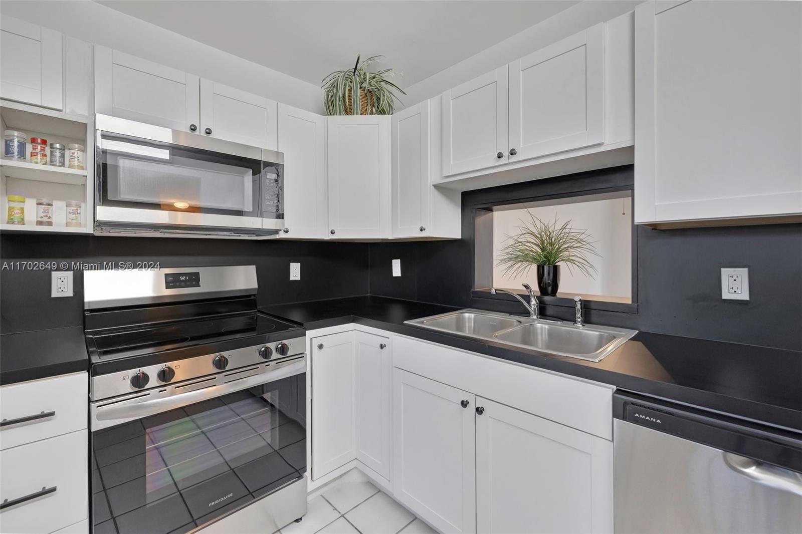 a kitchen with granite countertop a sink stainless steel appliances and cabinets