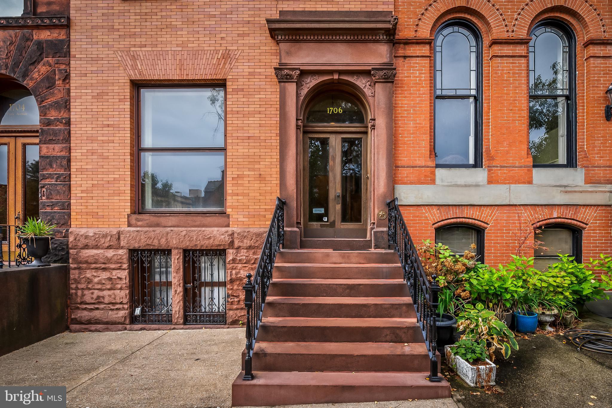 a front view of a house with plants and entryway