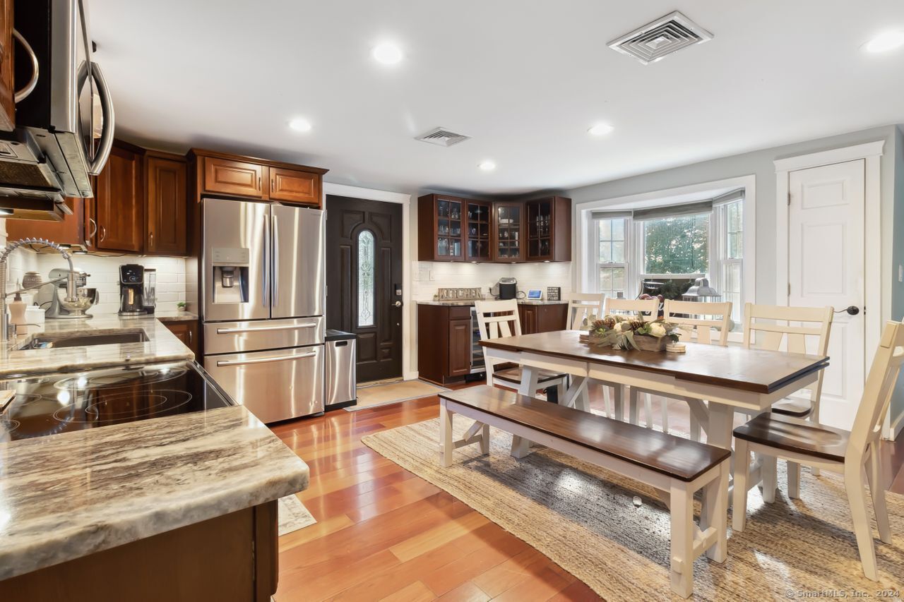 a kitchen with stainless steel appliances granite countertop a stove refrigerator and a sink