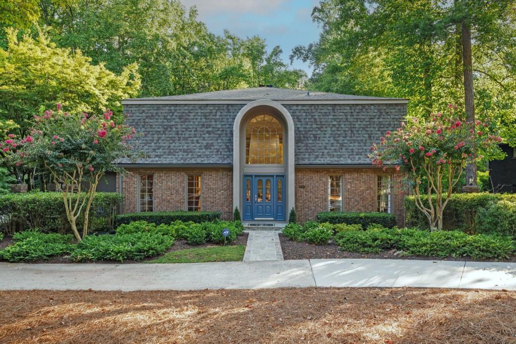 front view of a brick house with a small yard