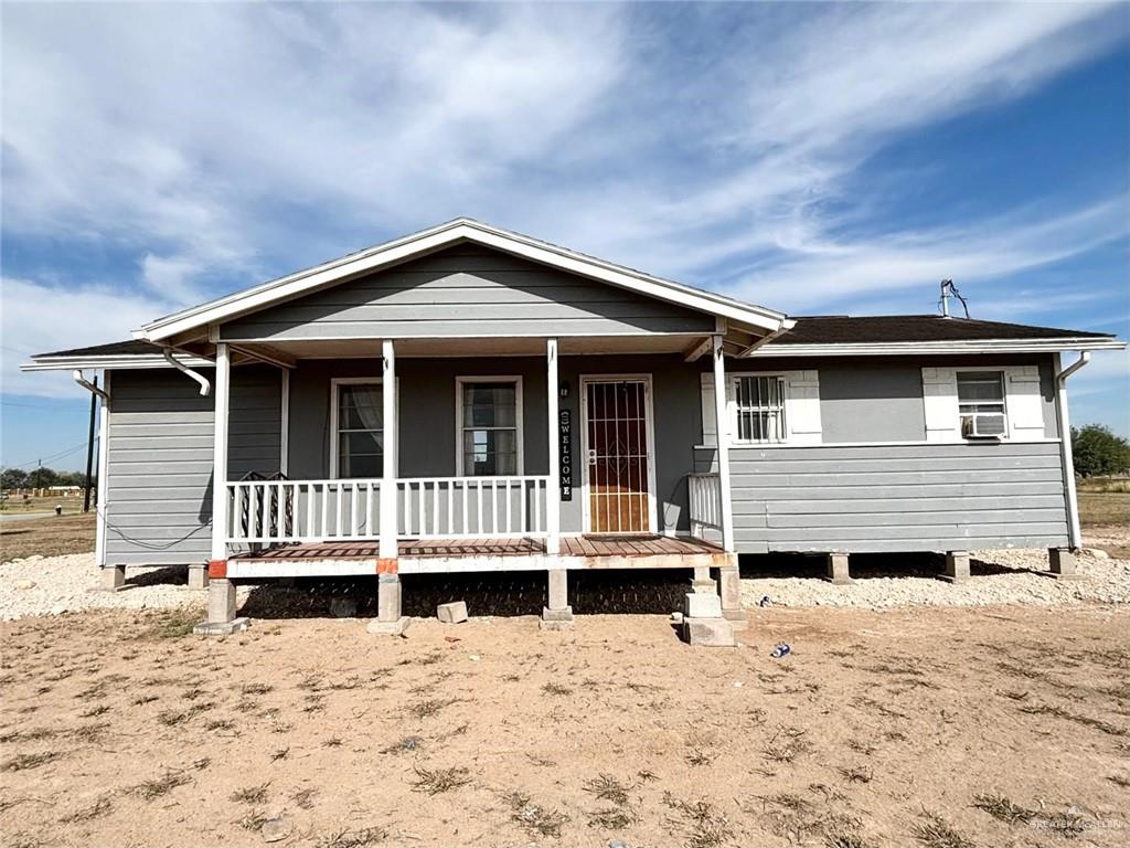 View of front of property with cooling unit and a porch