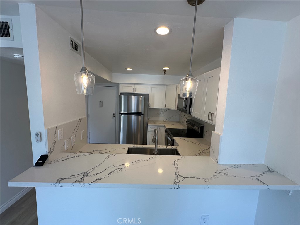 a kitchen with stainless steel appliances kitchen island a refrigerator and a counter top