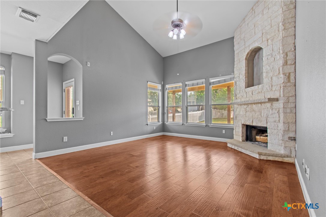 a view of an empty room with a fireplace and a window