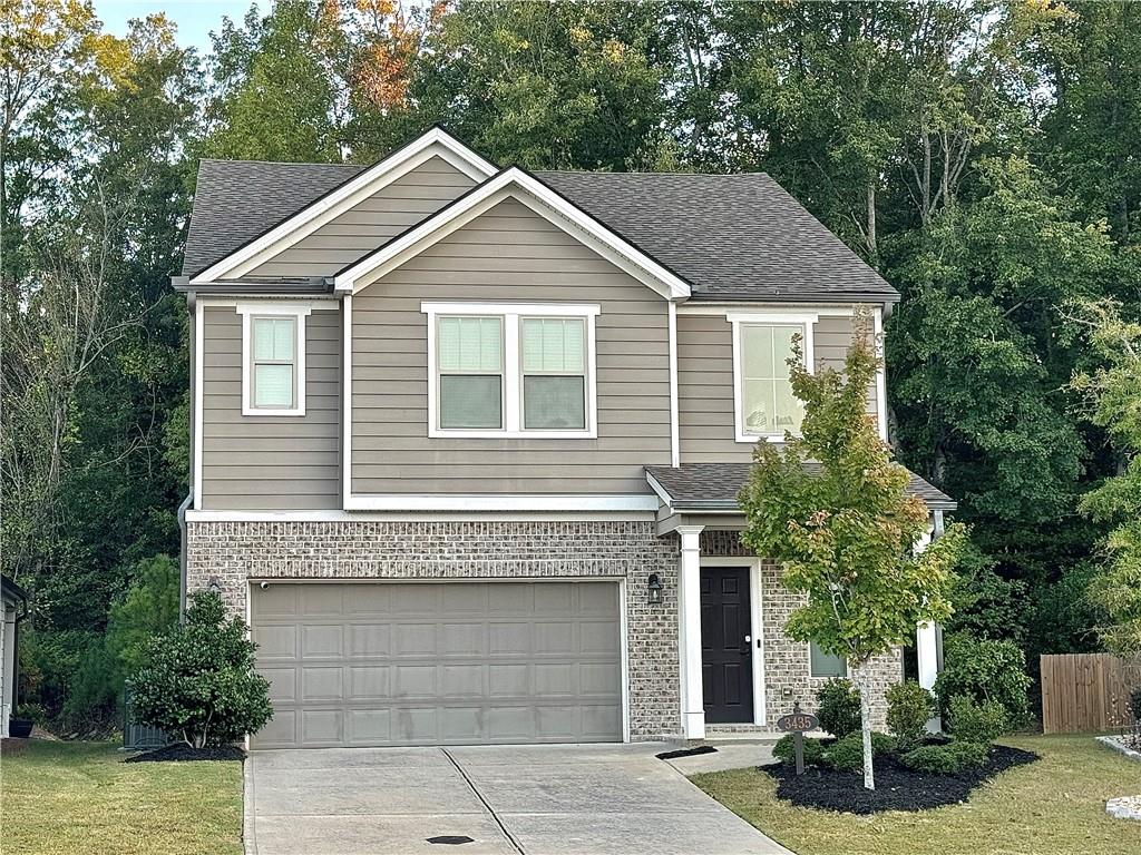 a front view of a house with a garden