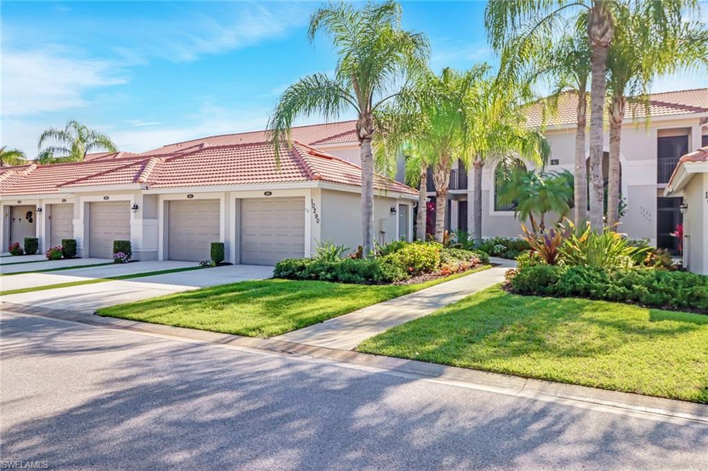 a view of a house with a yard and palm trees