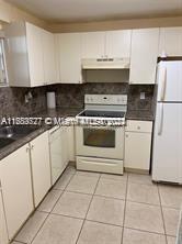 a white stove top oven sitting inside of a kitchen